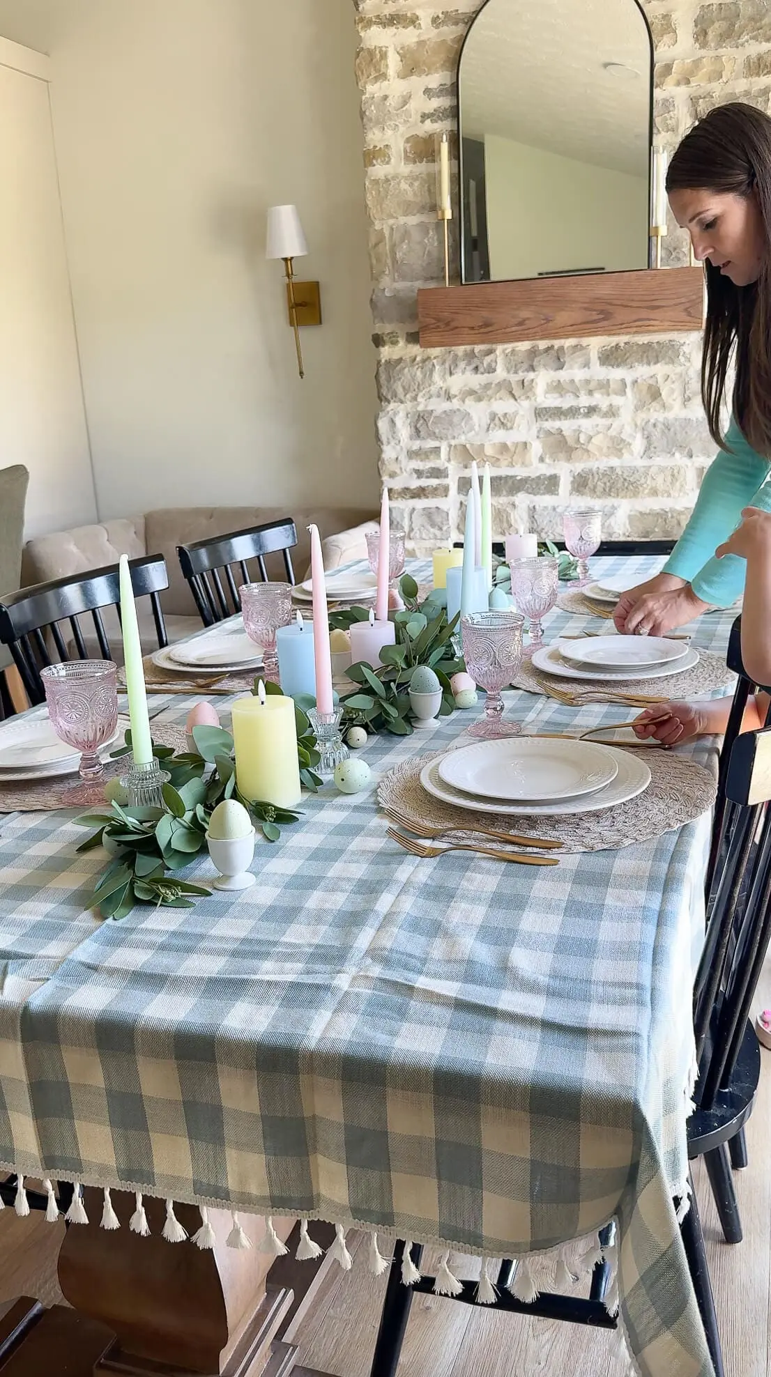 Mother and daughter setting plates and glassware as they complete the Easter table decor with finishing touches.